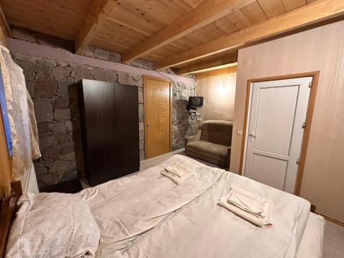 a bedroom with a bed with two towels on it at Family Hotel Parnas 2250 in Gudauri