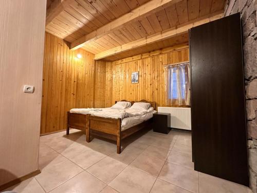 a bedroom with a bed in a wooden room at Family Hotel Parnas 2250 in Gudauri