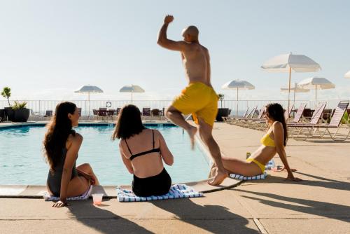 a group of people sitting around a swimming pool at Sound View Greenport in Greenport