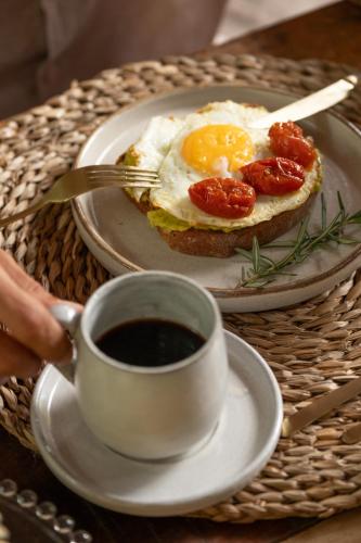 une tasse de café et un petit-déjeuner composé d'œufs et de pain grillé dans l'établissement Villa Rio Caraiva, à Caraíva