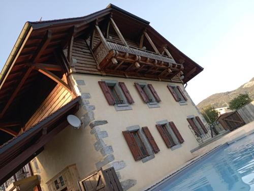 - un bâtiment avec des fenêtres en bois à côté d'une piscine dans l'établissement Les Clés de l Excellence, à Arenthon