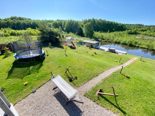 a white bench sitting in a field next to a boat at Mazurski Domek - Wake Up Home Ogonki in Ogonki