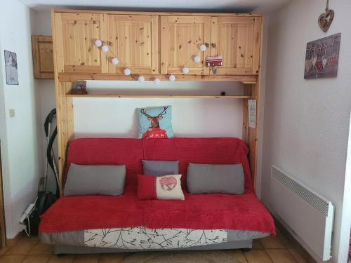 a red bed in a room with a bunk bed at Le Flocon, Joli Cocon des Neiges en Rez de Jardin - Les Rousses - Draps inclus & Parking gratuit in Les Rousses