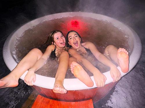 two girls are sitting in a hot tub at Pokoje Pod Modrzewiami in Ciche
