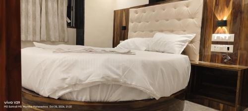 Un pat sau paturi într-o cameră la Hotel Sanjari International