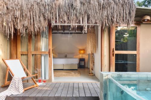 a resort with a bed and a swimming pool at Villa Rio Caraiva in Caraíva