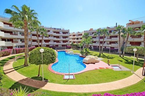 an apartment complex with a large swimming pool in a park at Casa Malibu El Rincon Pool view Playa Flamenca in Playa Flamenca