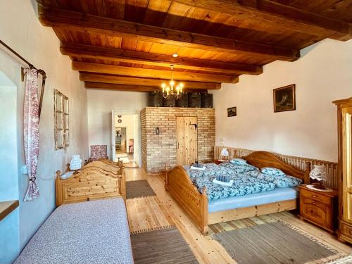 a bedroom with a large bed and a wooden ceiling at Öregfenyő Tornácosház in Bakonykoppány