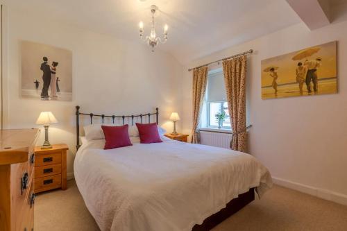 a bedroom with a large bed with red pillows at Shrimpers Cottage in Lytham St Annes