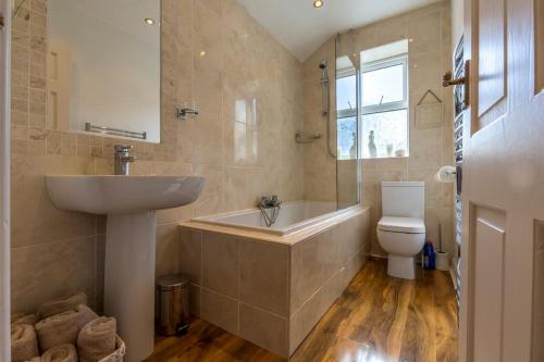 a bathroom with a sink and a tub and a toilet at Shrimpers Cottage in Lytham St Annes