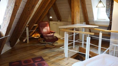una habitación con una silla y una mesa en un ático en Ferienwohnung Am Klosterhof, en Meersburg