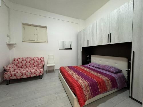 a bedroom with a bed and a chair at desHouse in Molfetta