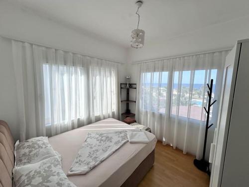 Un dormitorio con dos camas y una gran ventana. en Emerald Bay, en Yenimahalle