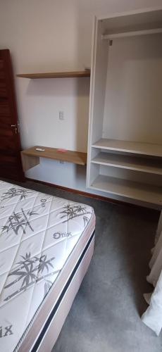 a bedroom with a bed and a book shelf at Morros da Barra chalé 19 in Cajueiro