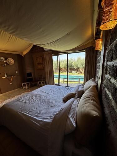 a bed in a room with a large window at Bin Jbal Resort in Ouirgane
