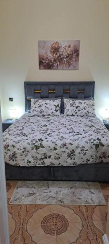 a bedroom with a bed with a flowery comforter at casa houda in Tangier