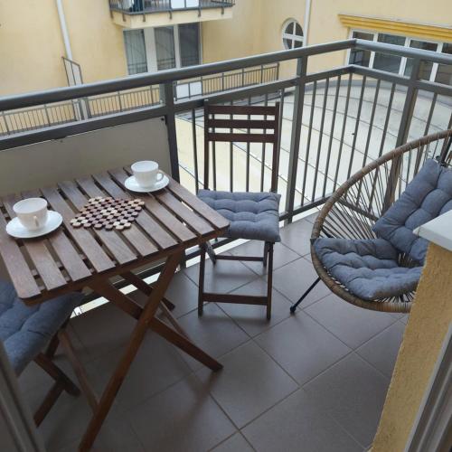 a wooden table and chairs on a balcony at Prestige Zalakaros Apartman in Zalakaros