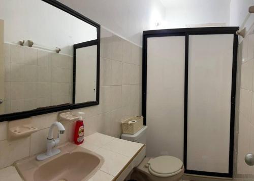 a bathroom with a sink and a toilet and a mirror at Casa Juan, Estudio en Cozumel in Cozumel
