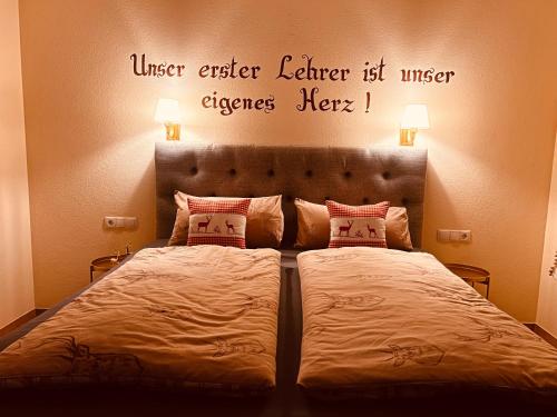 a bedroom with a bed with a quote on the wall at Sonnalm Panoramablick Garten Sauna in Rohrberg