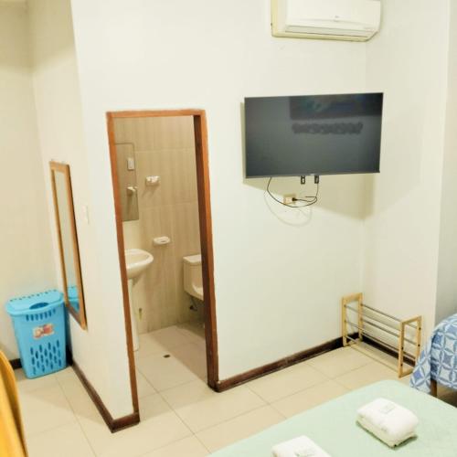a bathroom with a toilet and a tv on the wall at 100 RV APARTMENTS IQUITOS PERU-Apartamento primer piso con ventana a piscina in Iquitos