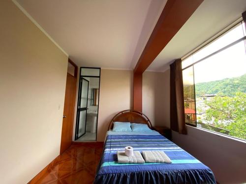 una camera da letto con un letto e una grande finestra di Casa Hospedaje Inkani a La Merced