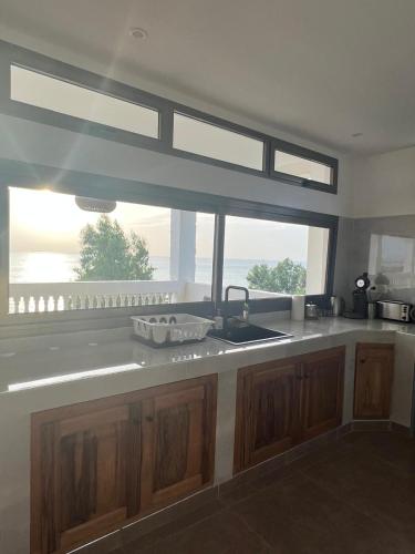 a kitchen with a sink and a large window at Villa Vista in Toubab Dialaw