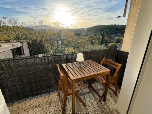 a wooden table and two chairs on a balcony at Cosy Cottage by Alice Village Provençal Sunshine in Fuveau
