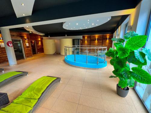 a room with a large plant and a blue table at Modern Mountain Apart 6 - an der Skipiste in Rauris