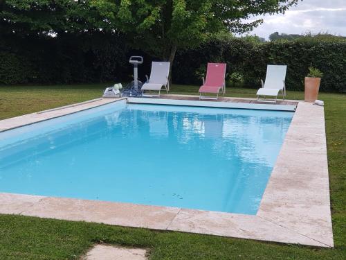 - une piscine avec 2 chaises dans l'établissement Les Chambres des 4 Vents - Chambres doubles à l'étage, à Saint-Paul-en-Pareds