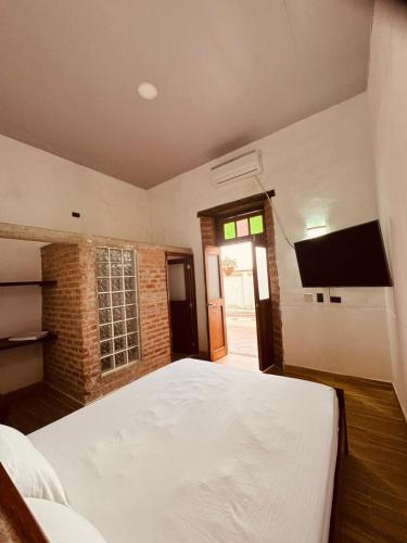 a bedroom with a bed and a flat screen tv at Casa Encanto Buga in Buga