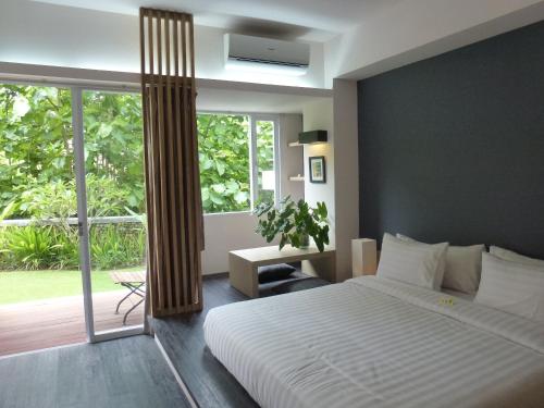 a bedroom with a bed and a large window at Allia Residence in Nusa Dua