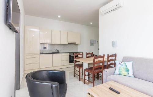 a kitchen and a living room with a table and a couch at Apartments Funtana with pool in Funtana