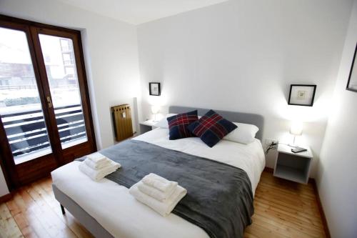 a bedroom with a large bed with two towels on it at Lovely Home with Breathtaking View of Mont Blanc in Courmayeur
