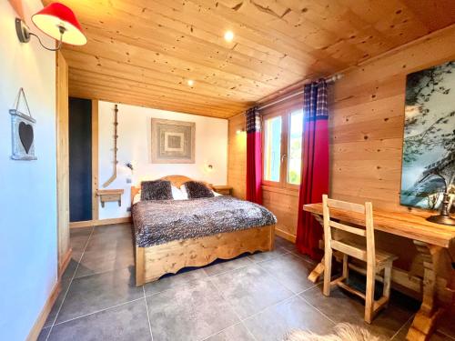 a bedroom with a bed and a desk in a room at Chambres à la ferme au pied des pistes de Megève in Demi-Quartier