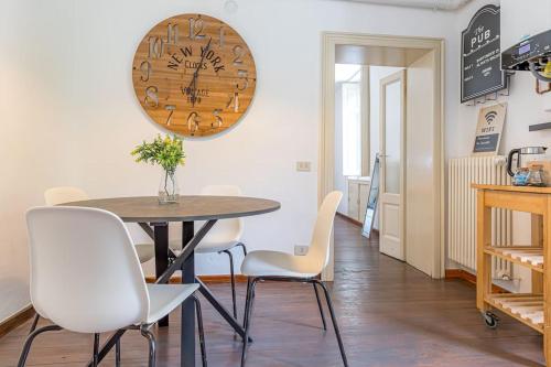 a dining room with a table and chairs and a clock at Ferro House in Como