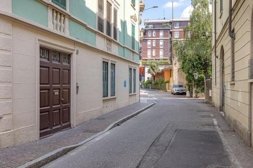 an alley with a brown door on the side of a building at Ferro House in Como