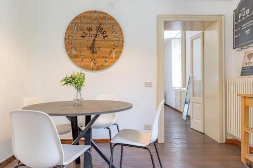 a dining room with a table and chairs and a clock at Ferro House in Como