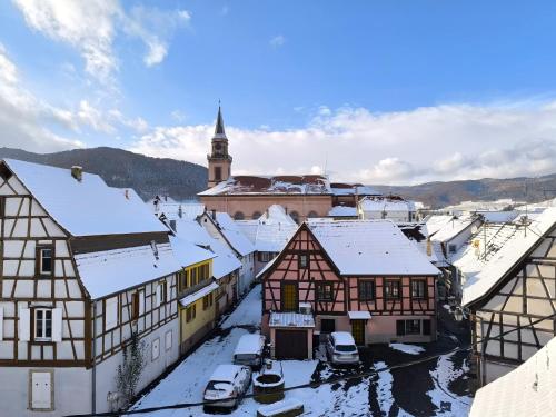 an old town with snow covered buildings and a church at Duplex moderne à 10 minutes de Colmar in Wintzenheim