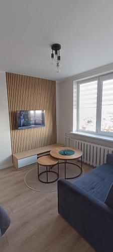 a living room with a couch and a table at SKY Studio flat in Panevėžys