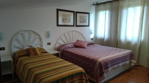 a bedroom with two beds next to a window at BeB Villa Licia Appartamento in Villa Basilica