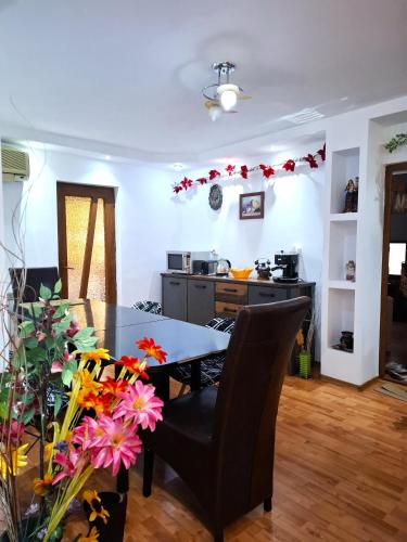 a kitchen and dining room with a table and flowers at 3-Room Delta Modern Residence in Tulcea