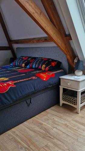 a bed with a blue comforter and a side table at Bed & Breakfast Moments in Schagen