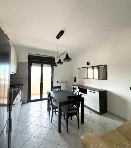 Una cocina y un comedor con mesa y sillas. en Rudy Apartment, en San Salvo