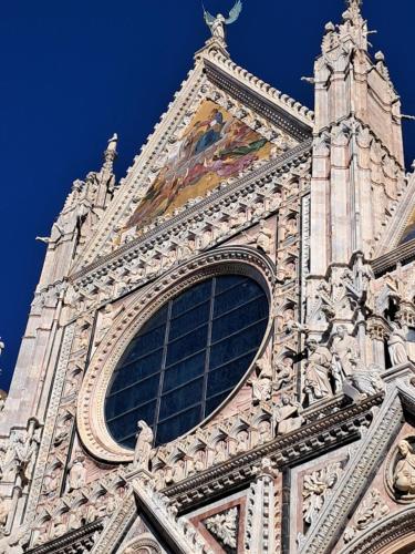 a tower of a building with a painting on it at Hotel Minerva in Siena