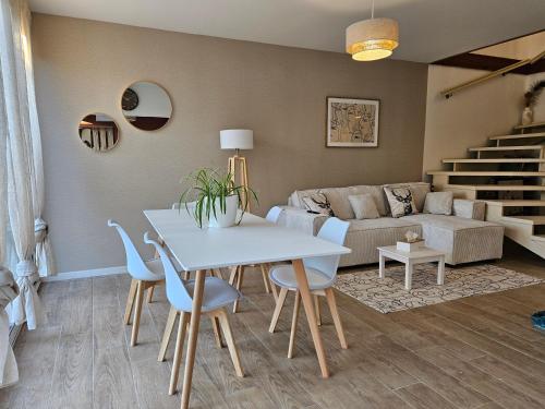 un salon avec une table, des chaises et un canapé dans l'établissement Jolie maison à guilherand-granges, à Guilherand