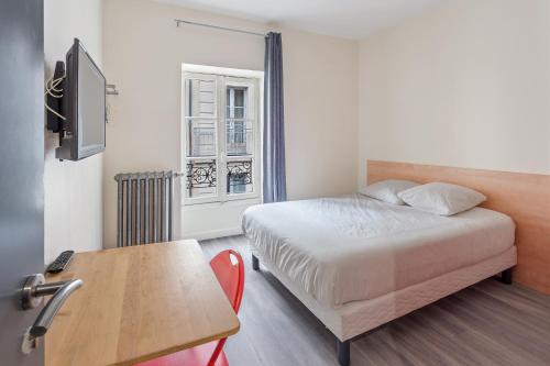 Un dormitorio con una cama, un escritorio y una mesa. en Chambres centre-ville avec espaces partagés - accessibles et abordables, en Nantes