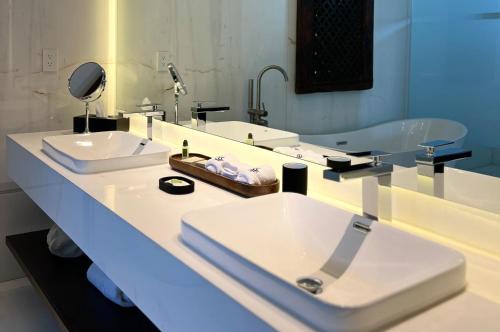 a bathroom with two sinks and a mirror at Casa Raíces Hotel Luxury & Viñedo in Los Galvanes