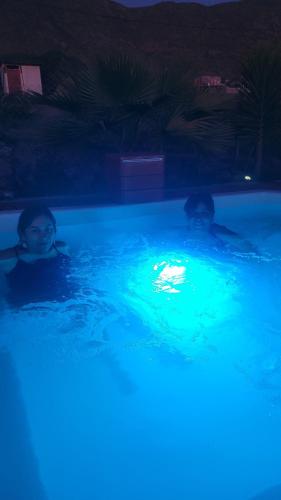 two people in a swimming pool with blue lights at Casas Rocamar in Totoralillo