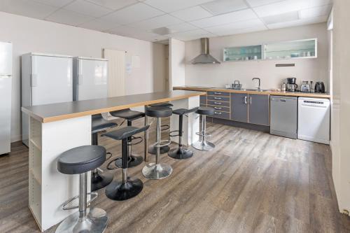 - une cuisine avec un comptoir et des tabourets dans l'établissement Chambres centre-ville avec espaces partagés - accessibles et abordables, à Nantes