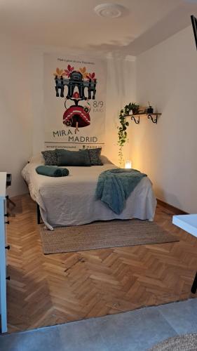 een slaapkamer met een bed en een poster aan de muur bij Estudio pequeño in Madrid